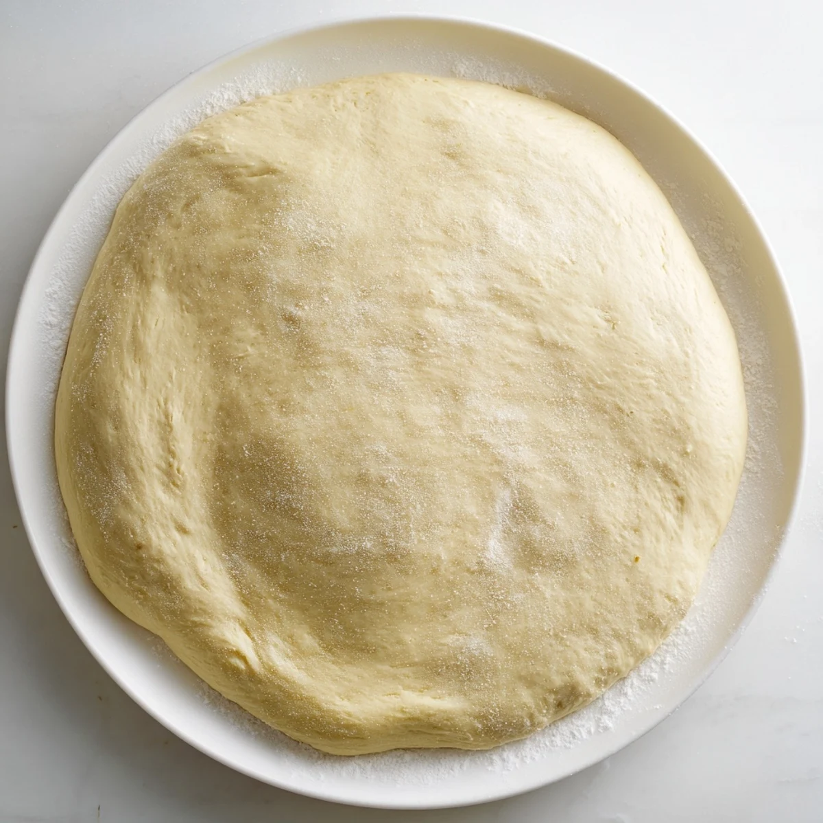 Golden, bubbly Homemade Pizza Dough ready for toppings, smelling heavenly and promising deliciousness.