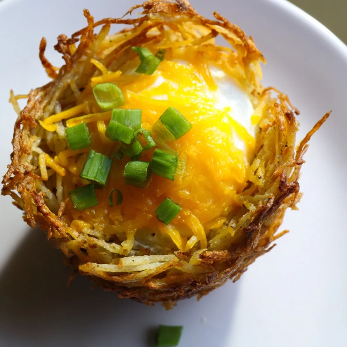 Close-up of baked Crispy Hashbrown Egg Nests with fluffy eggs, ideal for a hearty American breakfast.