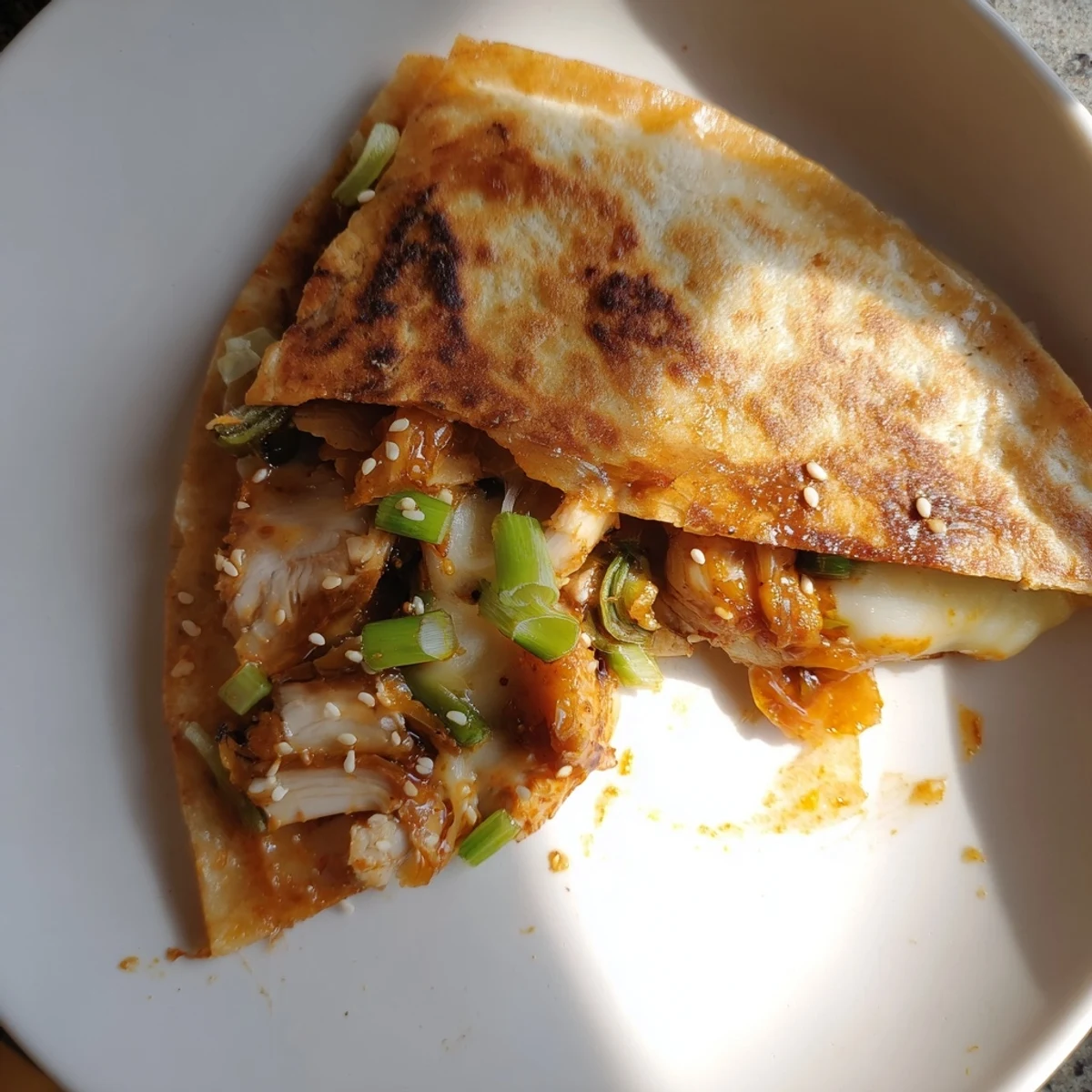 Golden, crispy Korean BBQ chicken wrap grilled cheese, oozing cheese and savory chicken filling.