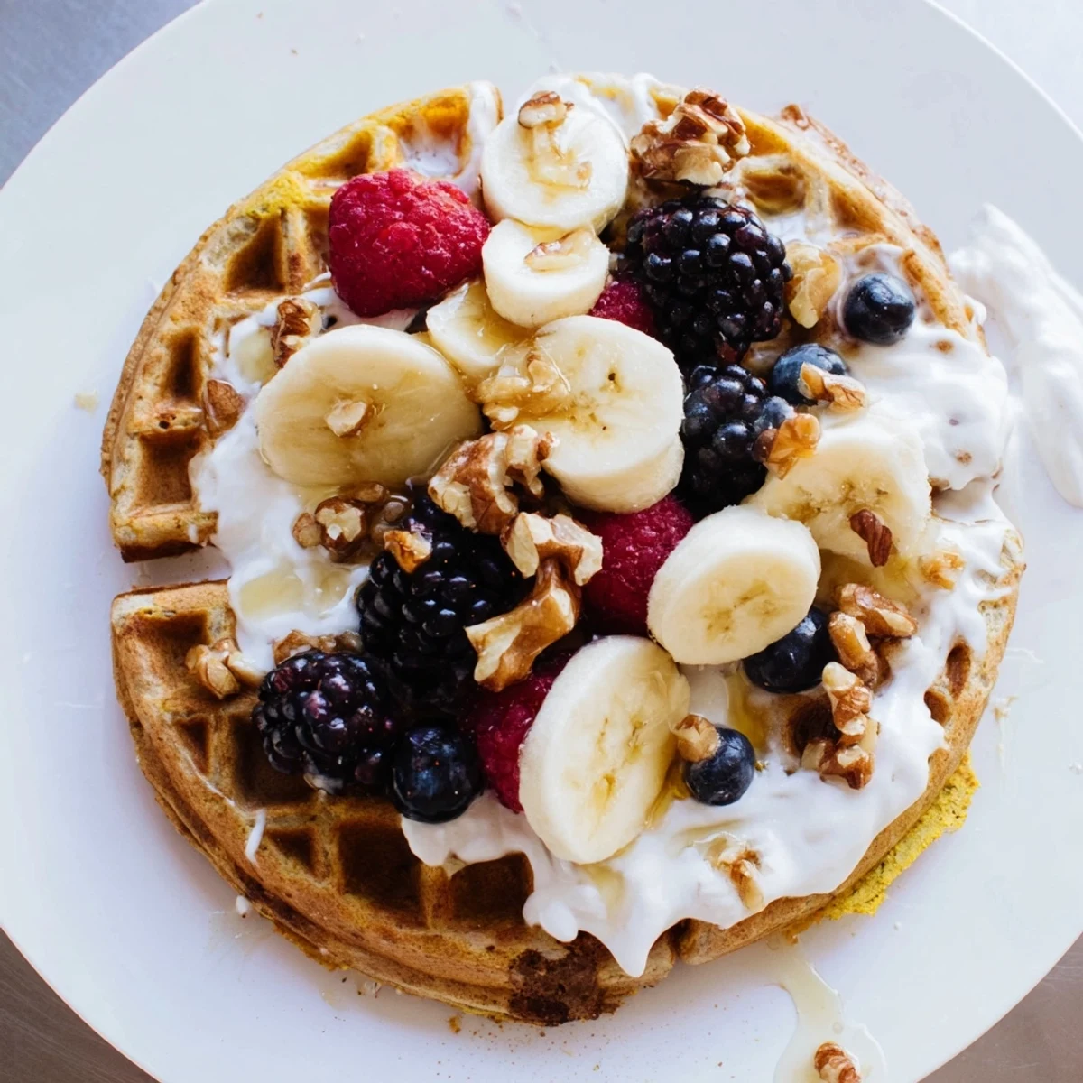 Golden, fluffy Anti-Inflammatory Adaptogenic Turmeric Waffles topped with fresh berries and a drizzle of maple syrup.  