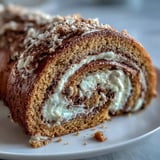 A freshly sliced Hojicha Roll Cake showing the tender sponge and rich roasted green tea cream, ready to serve.
