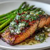 Garlic Butter Salmon with Asparagus: golden pan-seared fillets in a fragrant garlic butter sauce, served alongside crisp asparagus spears.