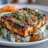 Golden crispy baked tofu bowl with vibrant vegetables and creamy peanut sauce.