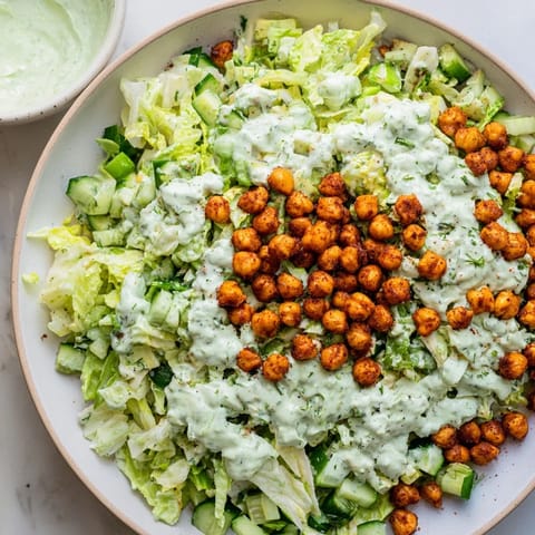 Top-down view of a fresh Green Goddess Salad, showcasing vibrant greens and crunchy chickpeas.