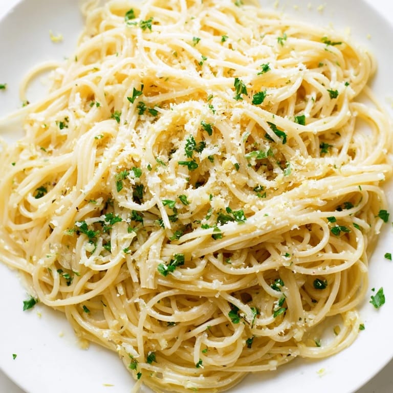 Quick and easy Garlic Butter Noodles, served in a bowl, with optional Parmesan cheese and lemon zest.