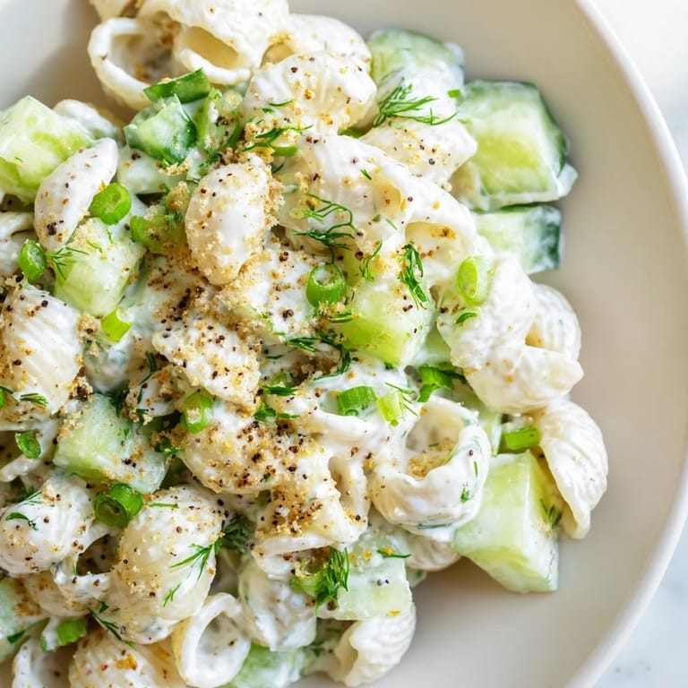 Chilled Cucumber Crunch Pasta Salad tossed in tangy dressing, featuring diced cucumbers and green onions, perfect for summer picnics.  