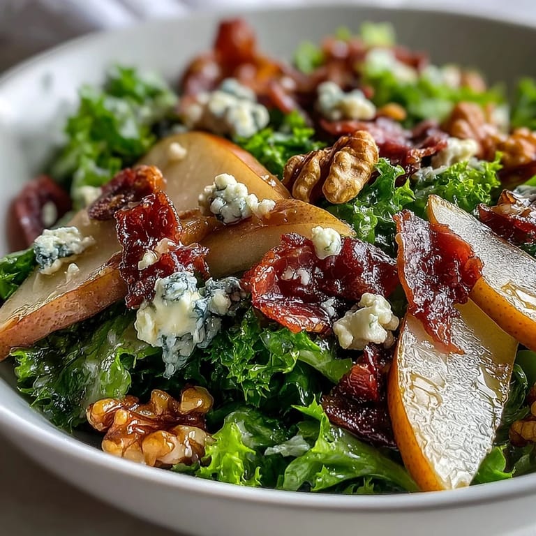 A close look at the Frisée Pear Blue Cheese Bowl salad showing crunchy greens, juicy fruit, and savory cured meat, plated ready to eat.