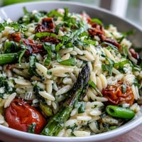 Spring Orzo Primavera with asparagus, zucchini, and parmesan in a creamy lemon sauce.  